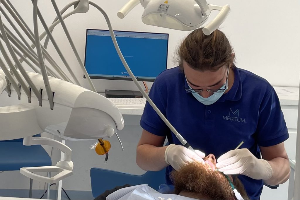 dentysta pochyla się nad pacjentem 