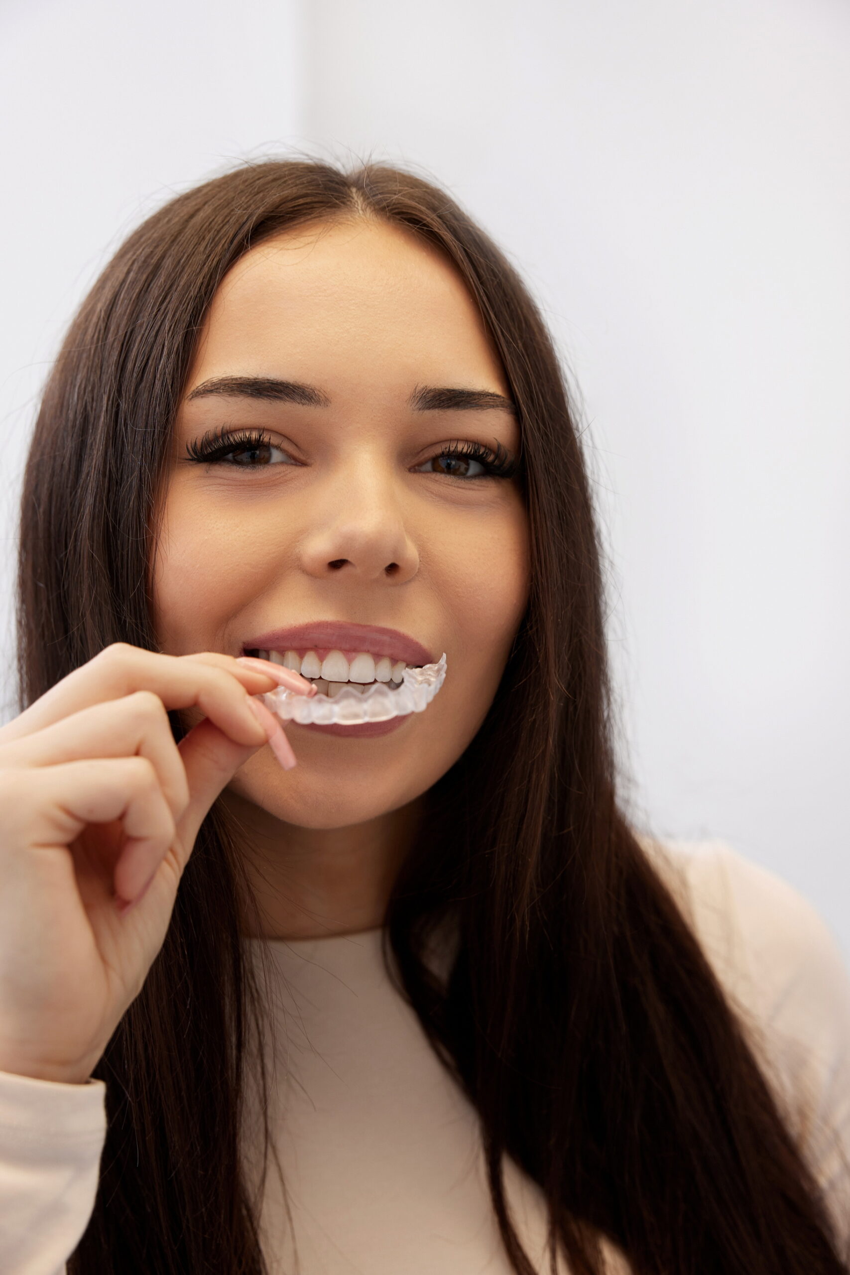 przezroczyste nakładki ortodontyczne Invisalign zakładanie na zęby pacjentki