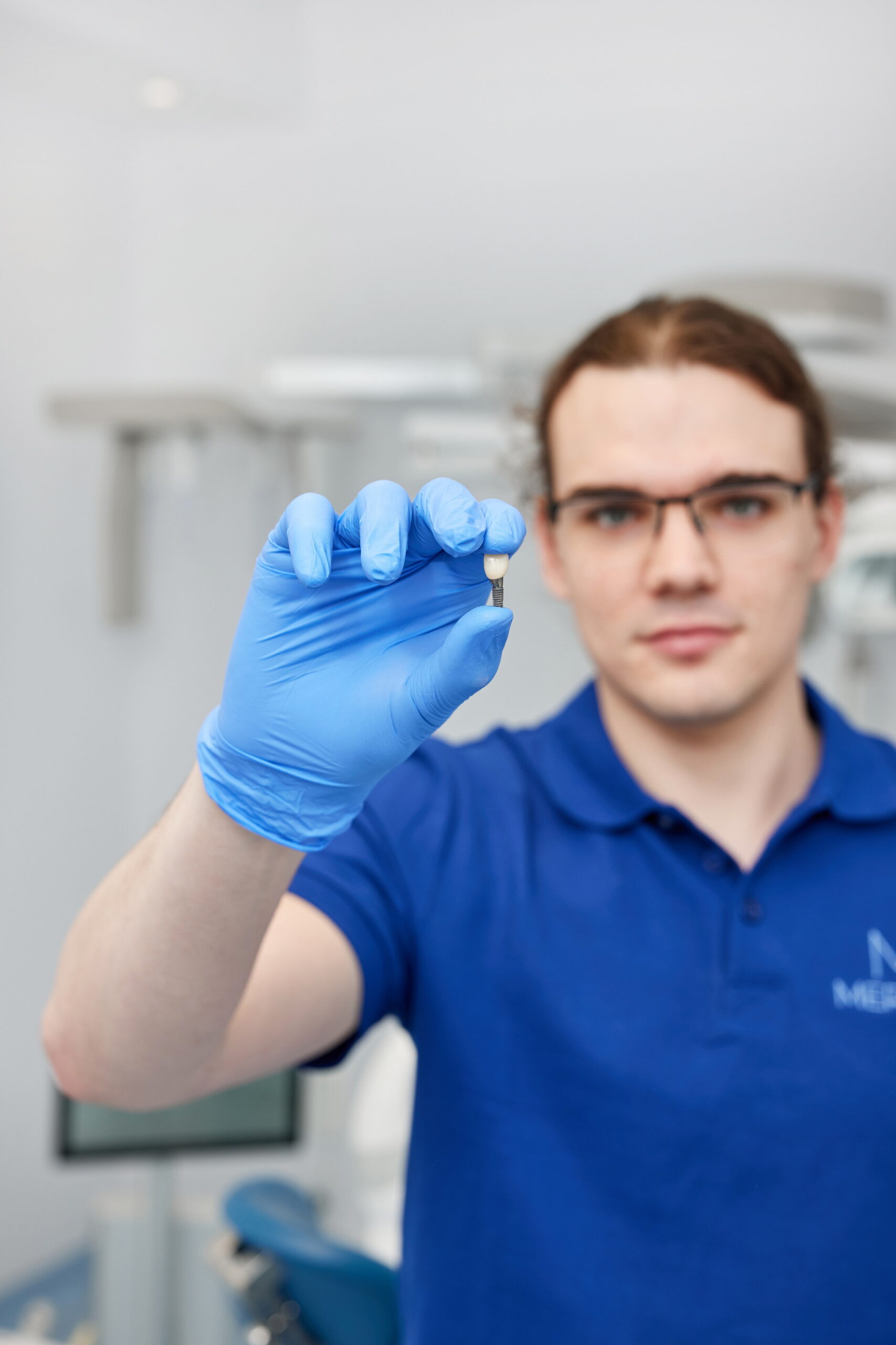 implant stomatologiczny w dłoni lekarza odbudowa po usunięciu zęba Łódź