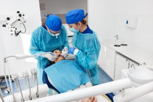 Zabieg usuwania zęba mądrości wykonywany przez dentystę w znieczuleniu