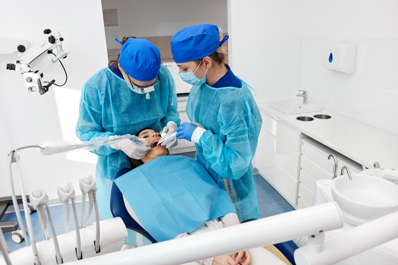 Zabieg usuwania zęba mądrości wykonywany przez dentystę w znieczuleniu