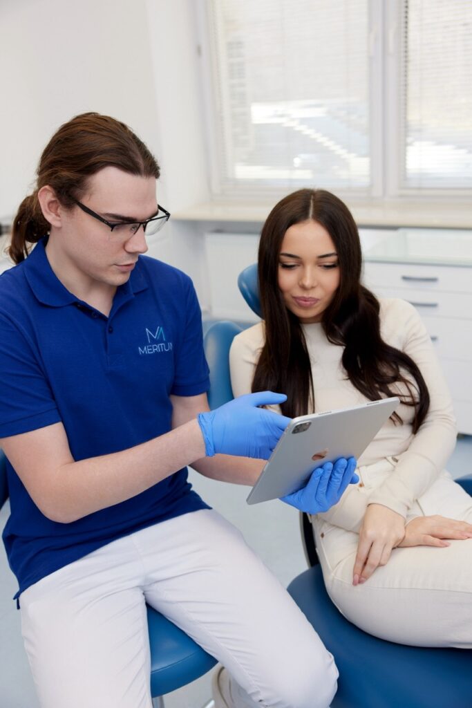 Dentysta omawia zalecenia po usunięciu zęba podczas wizyty z pacjentem