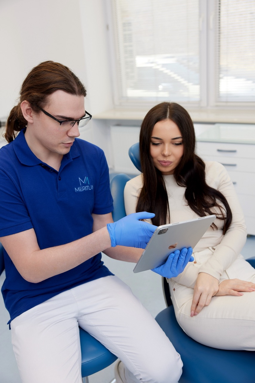 Dentysta omawia zalecenia po usunięciu zęba podczas wizyty z pacjentem