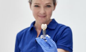dentysta prezentuje implant zębowy na konsultacji stomatologicznej