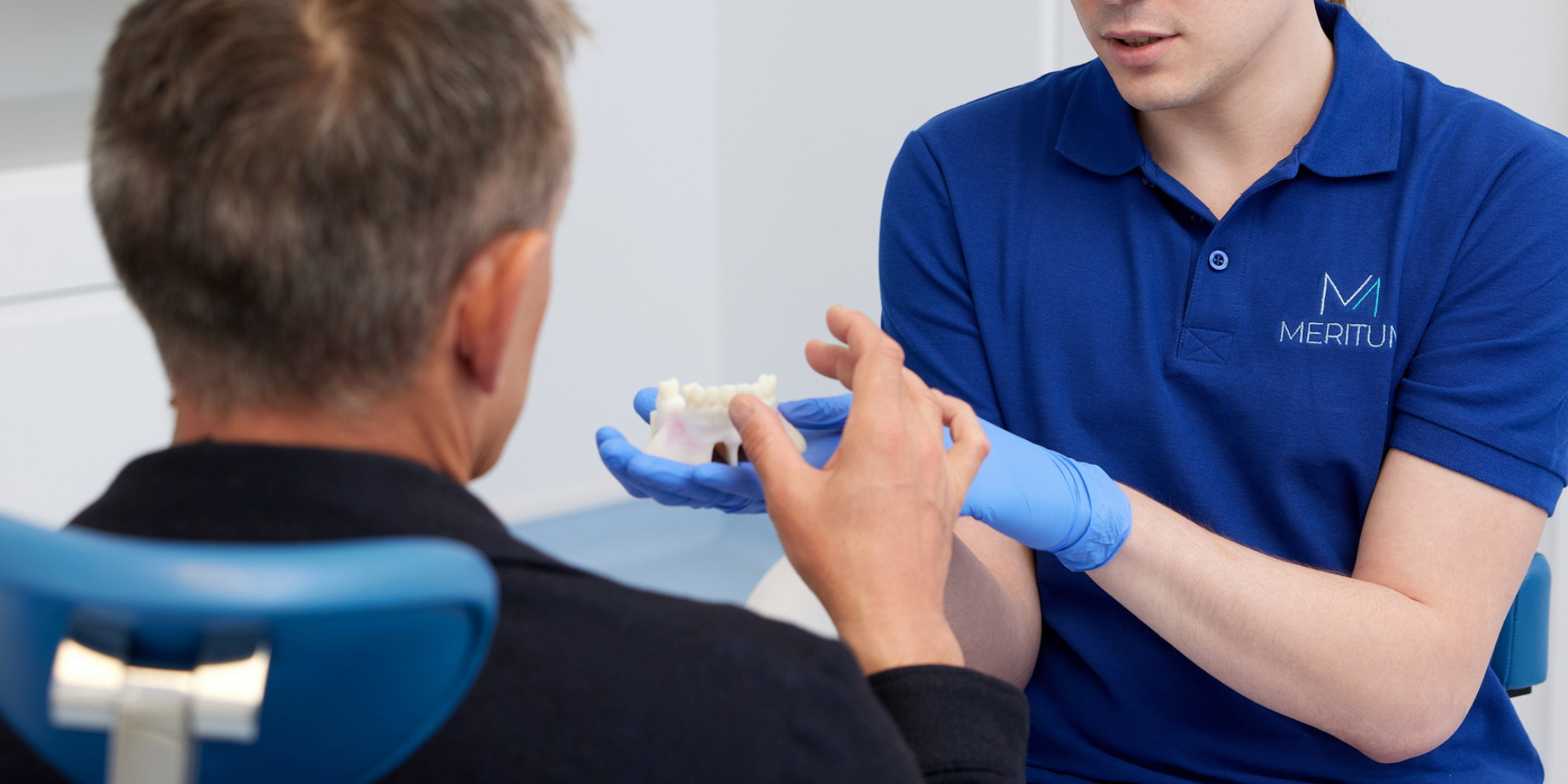 konsultacja implantologiczna lekarz omawia protezę na implantach z pacjentem Łódź